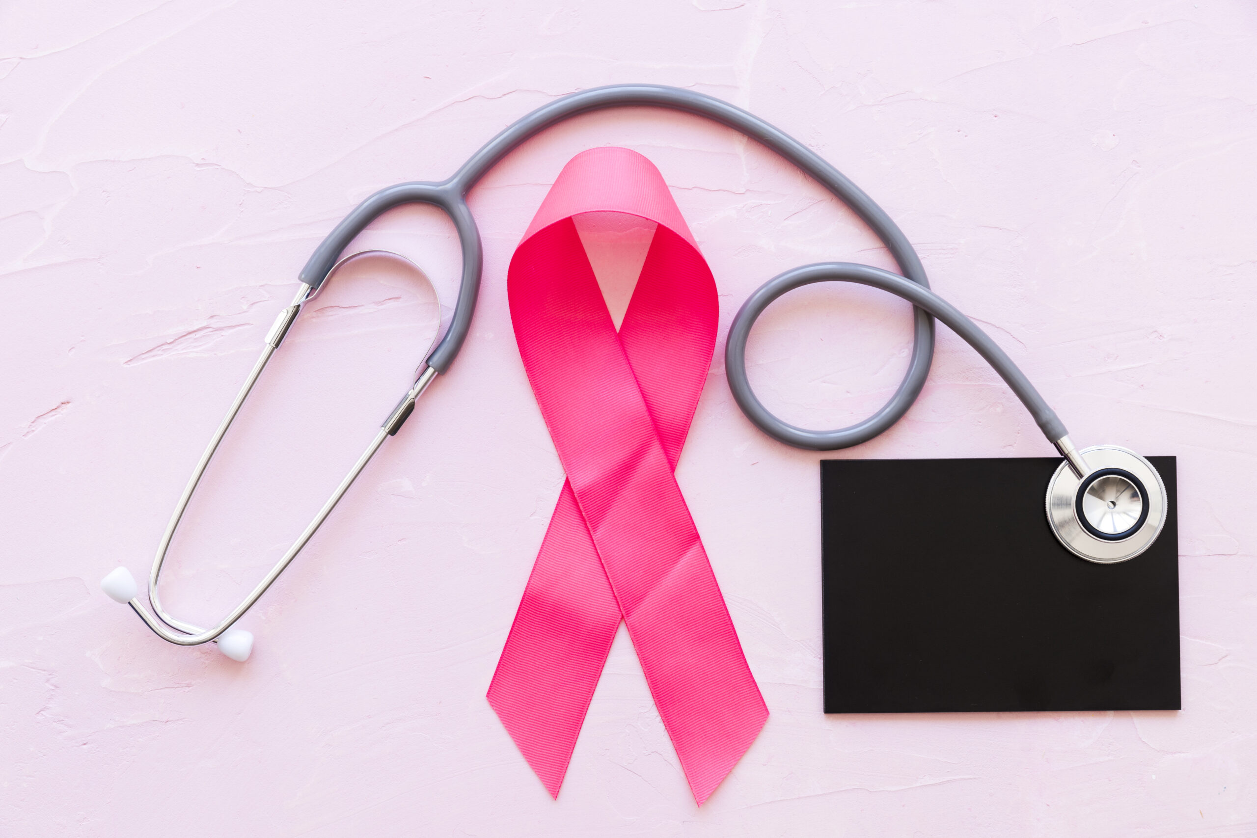 imagem de laço de fita rosa e estetoscópio médico